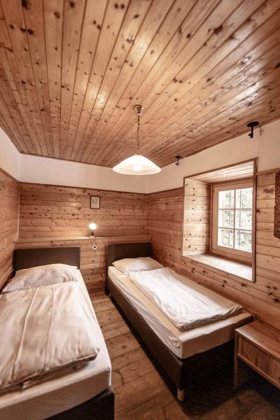 Zwei Einzelbetten, Decke und Seitenwände sind mit Holz ausgekleidet.