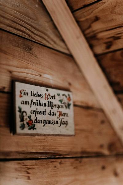Ein Spruch auf einer Holzplatte geschrieben und montiert an der Holzwand.